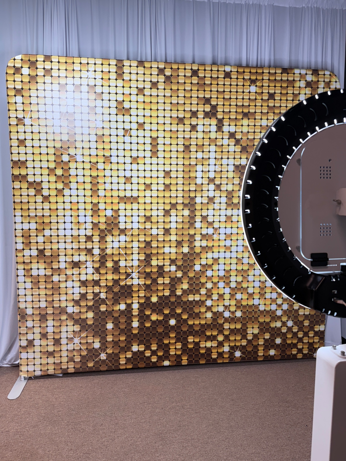 Quick Drop photo booth beside a shimmering gold backdrop